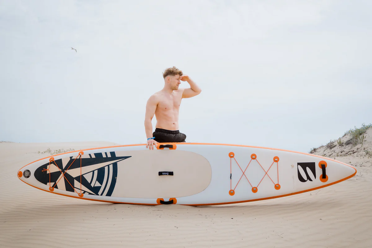 Bass SUP MorningStar 13.3 – młody mężczyzna z deską SUP na słonecznej plaży w Hiszpanii