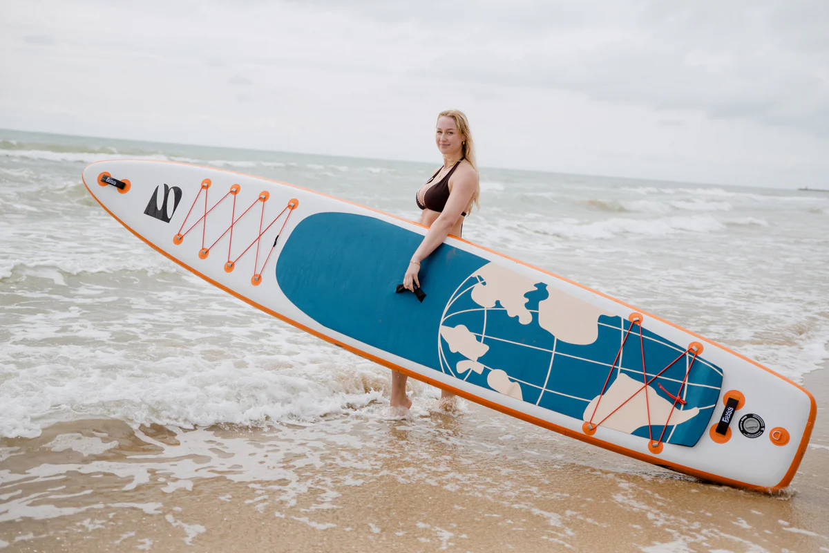 Bass SUP Explorer 14 – młoda kobieta z deską SUP nad morzem w Hiszpanii
