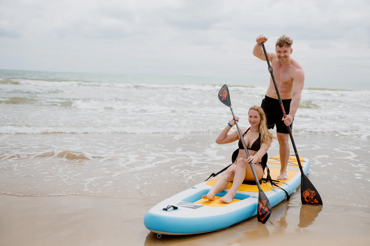 Bass SUP Trinity 13.8 – para pozuje z deskami SUP na plaży w słonecznej Hiszpanii