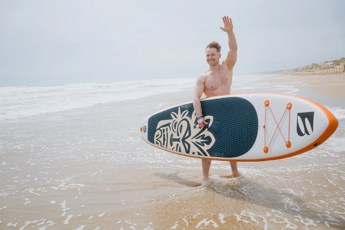 Bass SUP Wind and Wing 10 – młody mężczyzna z deską SUP nad morzem w Hiszpanii