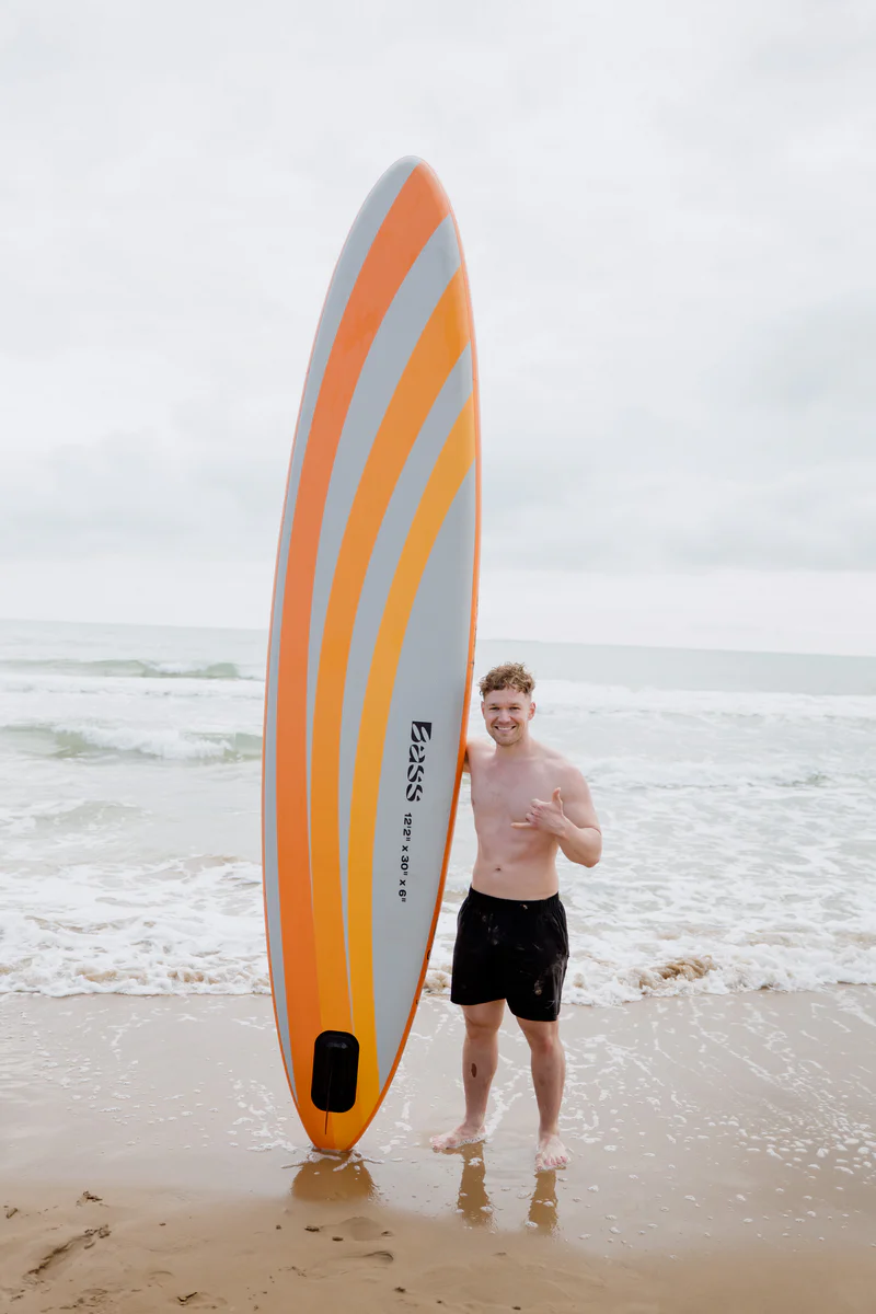 Blight SUP 12 – młody mężczyzna z deską SUP na plaży w Hiszpanii